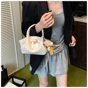 Detail of white crocodile pattern PU leather bucket bag with cute teddy bear charm