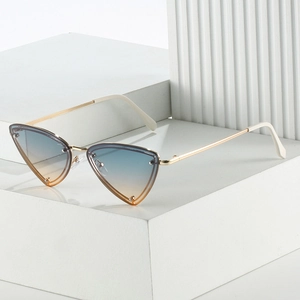 Close-up of cat-eye triangle sunglasses with gradient lenses and gold metal temples