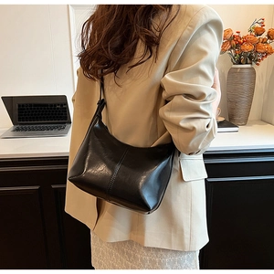Détail d'un sac sous les bras noir brillant minimaliste avec coutures verticales