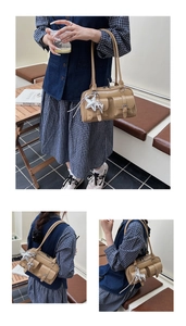 Detail of tan shoulder bag with crocodile pattern pockets and star pendant charm