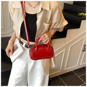 Chic red leather handbag with silver rivets in a stylish street fashion setting