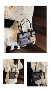 Close-up of deep brown tote bag with dual front pockets and cute plush bear charm accessory