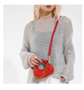 Detail of red crescent bag showing lychee grain leather and bold gold chain strap