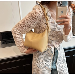 Vue détaillée du sac hobo beige avec un nœud 3D décoratif sur la bandoulière