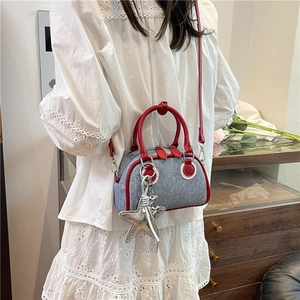 Blue denim bowling bag with red contrast leather trim and silver star pendant for women