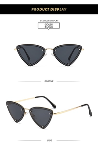 Macro detail of vintage triangle sunglasses with gold metal frame and black lenses