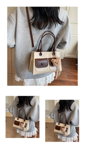 Close-up of a two-tone tote bag featuring front flap pockets and a cute bear charm