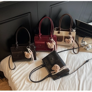 Detail view of stylish tote bags in four colors with multi-pockets and plush bear charms