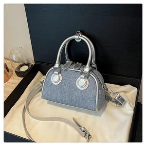 Blue denim mini handbag with silver metal handles and strap inside a luxury gift box