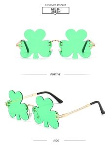 Detail view of rimless clover leaf sunglasses with green lenses and gold metal frames