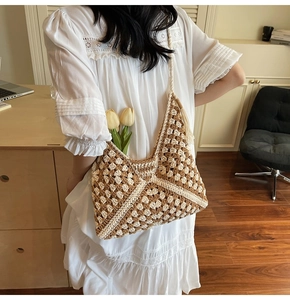 Detail view of large crochet beach tote bag with geometric patterns and tassel charm