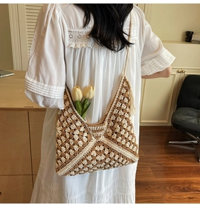 Close-up of handmade woven tote bag featuring geometric crochet texture and tassels