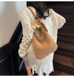 Detail view of woven hobo bag featuring floral cutout patterns and a leather tassel
