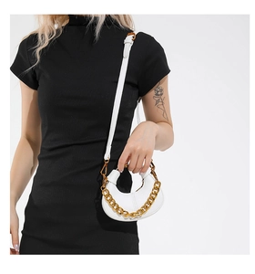 Détail de mini sac blanc en cuir grainé avec une poignée décorative en chaîne dorée