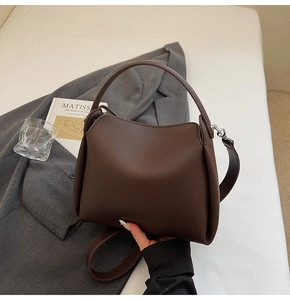 Vue détaillée du sac seau en cuir grainé marron foncé avec finitions en métal argenté