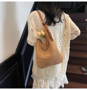Vista trasera de una mujer con un elegante bolso cubo de ganchillo con borla en una escalera