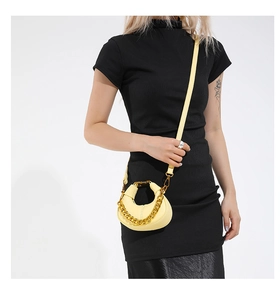 Close-up of bright yellow crescent bag featuring lychee texture and golden chain detail