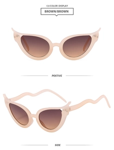 Détail de lunettes de soleil œil-de-chat avec branches ondulées et verres bruns dégradés