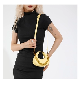 Pale yellow crescent crossbody bag with chunky gold chain and textured litchi leather