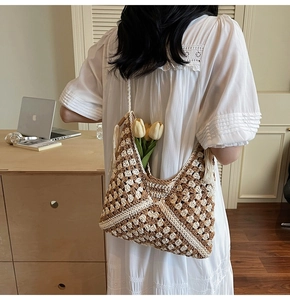 Detail of hand-crocheted boho hobo bag with geometric patterns and tassel detail on model