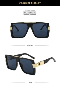 Detail of square oversized black sunglasses with gold infinity metal temple accents