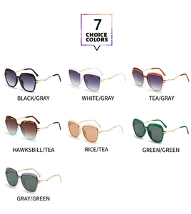 Detail of seven colored oversized cat-eye sunglasses with wavy gold metal temples