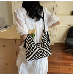 Detail of checkered crochet tote bag with long black side tassels and wide shoulder strap