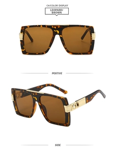 Detail view of leopard square sunglasses with brown lenses and golden bow accents