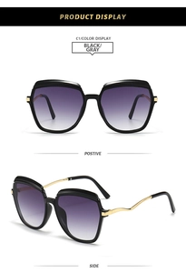 Detail of square black sunglasses with purple gradient lenses and wavy gold metal temples