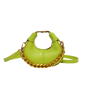 Chic green crescent bag with pebbled leather texture and decorative gold chain