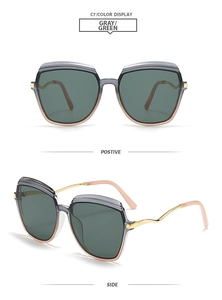 Detail of square frame sunglasses with grey-green lenses and golden wavy temples