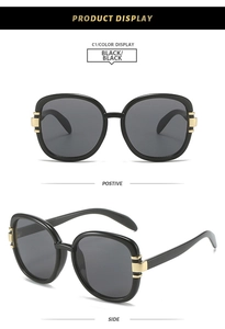 Detail view of black square oversized sunglasses with gold striped metal temple accents