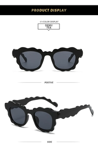 Detail view of wavy black frame sunglasses with dark grey polarized lenses