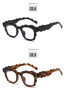 Detail view of wavy edge eyewear frames in glossy black and tortoise shell finishes
