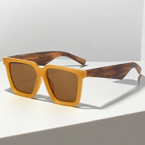 Detail of yellow square sunglasses with tortoiseshell temples on a geometric platform