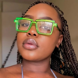 Close-up of 2D cartoon style square neon green glasses with bold black outlines on a model