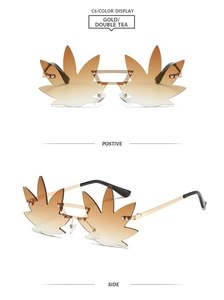 Close-up of rimless leaf shaped sunglasses with gold metal frame and gradient tea lenses