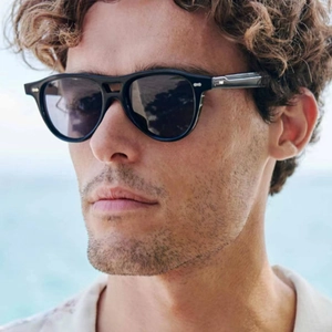 Close-up of stylish double-bridge pilot sunglasses with silver metal hardware on black frame