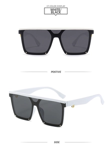 Detail view of square flat-top sunglasses in black and white with gold rivet accents