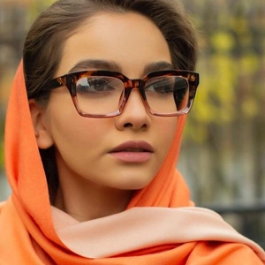 Detail of tortoise gradient rectangle glasses frames paired with a silk scarf on model