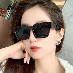 Nahaufnahme eines Models mit schwarzer eckiger Sonnenbrille und breiten Bügeln