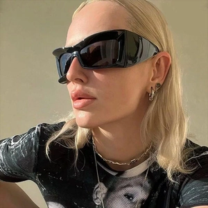 Close-up of oversized black chunky square sunglasses worn by a model in natural light