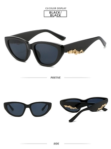 Detail of black cat-eye sunglasses with golden wave pattern on temple and metal accents