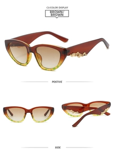 Detail view of cat eye sunglasses with golden wave metal trim on brown gradient frames