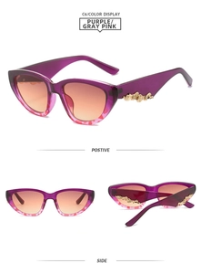Detail view of purple cat eye sunglasses with vintage gold embossed scrollwork temples