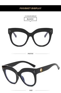 Detail view of black cat-eye glasses frame with three metal rivets and golden hinges