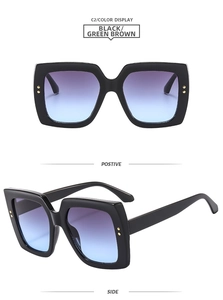 Detail view of square black sunglasses with gold accents and purple-blue gradient lenses