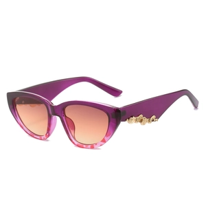 Stylish cat-eye sunglasses with purple gradient frame and warm orange lenses, 45-degree view