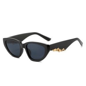 Retro cat-eye sunglasses in shiny black with decorative golden wave-patterned temples