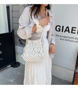 Close-up of white crochet hollow bucket bag with diamond weave and drawstring detail